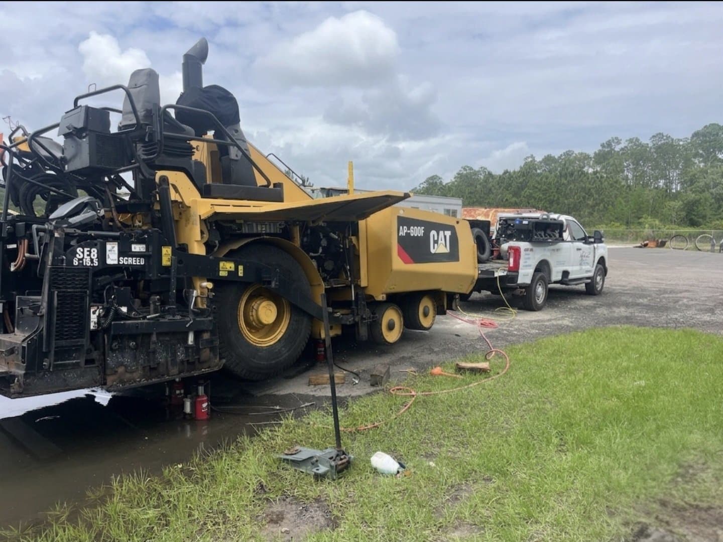 K&W Mobile Tire Service truck parked next to a Cat AP-600F paver receiving on-site tire service at a Central Florida job site