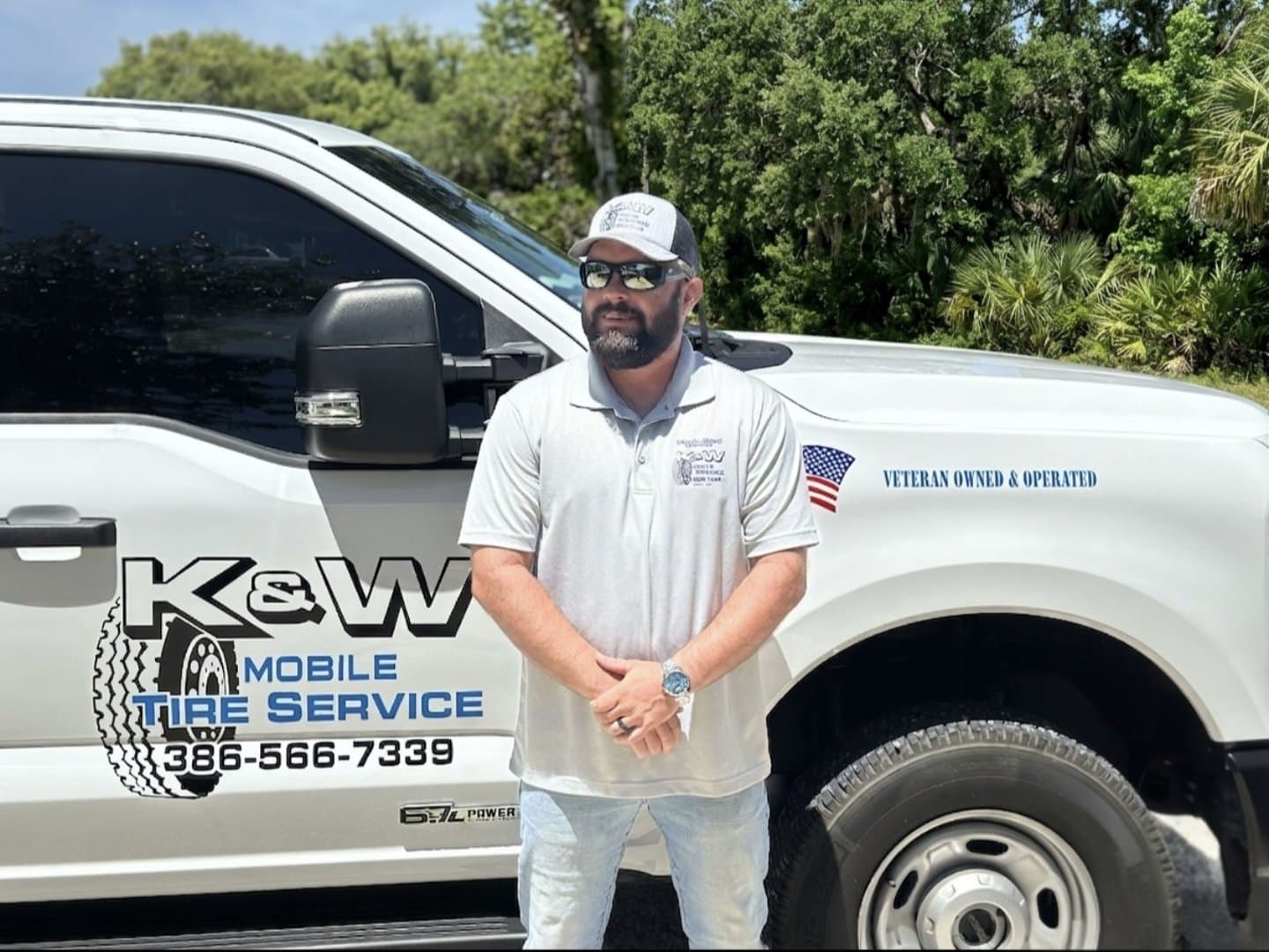 Dustin Boyd, owner of K & W Mobile Tire Service, standing in front of the branded K & W service truck with Veteran Owned & Operated signage — U.S. combat veteran running the mobile tire company headquartered in Edgewater, Florida