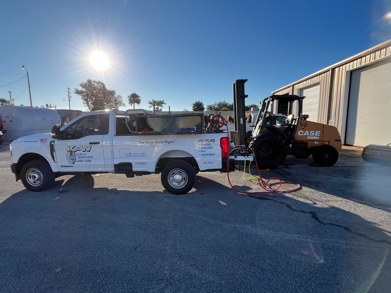 K & W Mobile Tire Service truck performing on-site forklift tire replacement at a warehouse in Central Florida — pneumatic and solid forklift tires handled at the dock